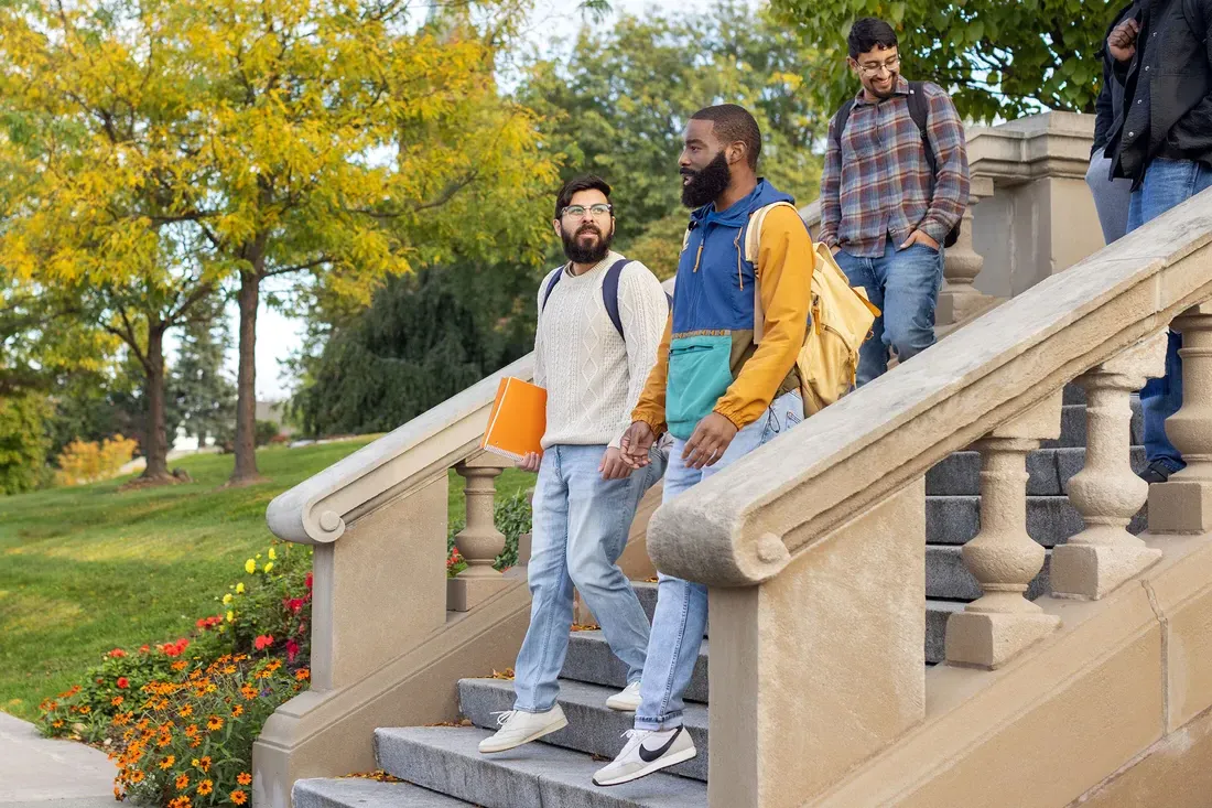 Three students walking outside on campus together.